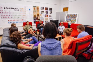 Students sit in red chairs around visiting artist.