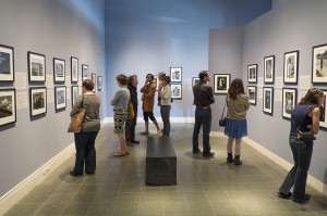 People study photography on walls in museum